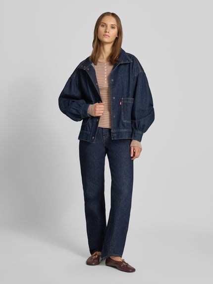 Frauenmodel trägt Slim Fit Langarmshirt aus reiner Baumwolle von REVIEW, gestreift, mit Rundhalsausschnitt und Knopfleiste, Ganzkörperansicht von vorne.