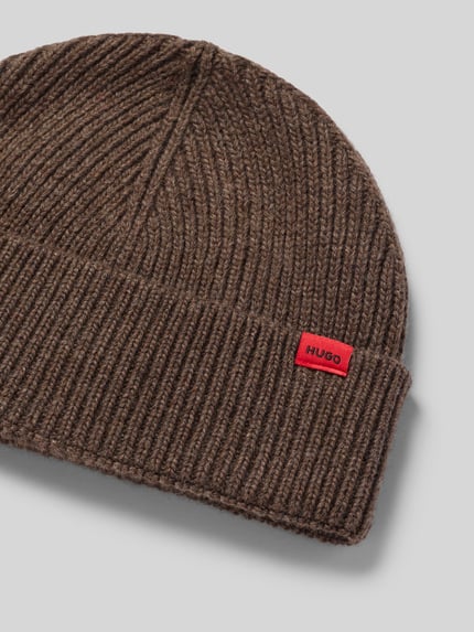 Produktfoto, Mütze mit Logo-Patch Modell 'Xisk' von HUGO in brauner Strickoptik mit strukturierter Rippstrick-Oberfläche, breite Krempe.