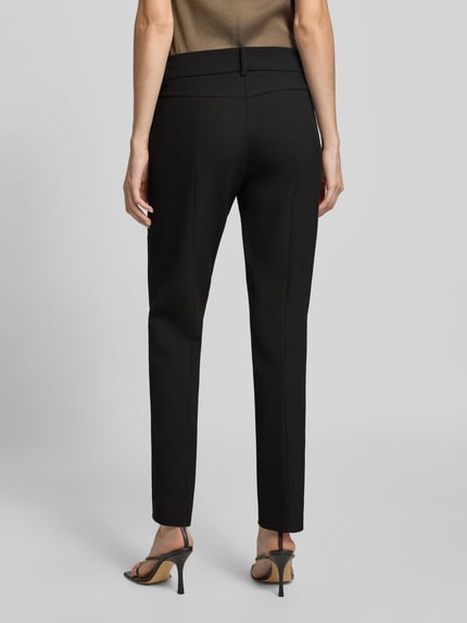 Frauenmodel trägt Slim Fit Hose aus Webware mit Bügelfalten Modell 'SARAH' von CAMBIO, Damen Schmale Hose, schwarze Farbe, Ganzkörperansicht Rückansicht.