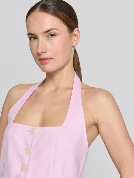Frauenmodel trägt Weste aus Leinen mit Neckholder Modell 'BORELI' von Mango in zartem Rosa, Knopfleiste, Karree-Ausschnitt, taillierter Schnitt, Nahaufnahme Oberkörper.