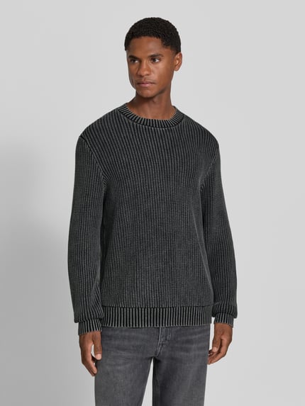 Męski model nosi sweter z dzianiny z prążkowanymi wykończeniami Strickpullover mit gerippten Abschlüssen von Antony Morato, bawełna, krój regular fit, Długość tyłu w rozmiarze M: 70 cm, Długość rękawów w rozmiarze M: 69 cm, widok z przodu całej sylwetki.