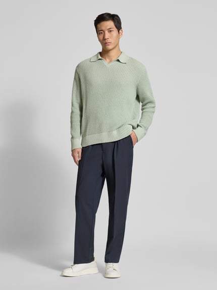 Mannmodel draagt Relaxed Fit Strickpullover aus reiner Baumwolle Modell 'DERECK' van SELECTED HOMME, effen lichtgroen, grofgebreid, shirtkraag, lange mouwen, geribde boorden, geheel van voren te zien.