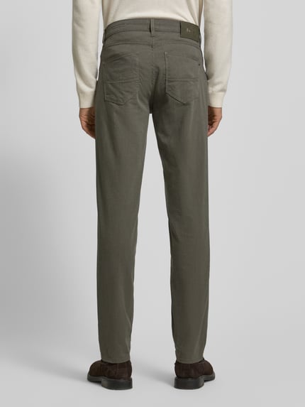 Mężczyzna nosi Slim Fit Stoffhose mit 5-Pocket-Design Modell 'Cadiz' od Brax, bawełniany miks ze stretchem, szaro-zielony, widok z tyłu, całe ciało.