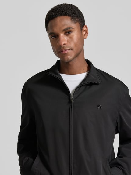 Männermodel trägt schwarzen regular fit blouson mit gestikt logo, Regular Fit Blouson mit Logo-Stitching Modell 'H-CARVO' von BOSS, heren blouson. Nahaufnahme Oberkörper.