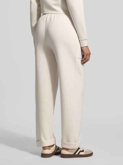 Vrouwenmodel draagt Sweatpants mit Eingrifftaschen und Aufschlag van Christian Berg Woman, Materiaalmix met modalmix, relaxed fit, steekzakken, omslag. Volledige achteraanzicht.