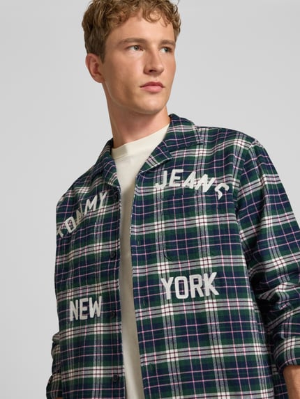 Männermodel trägt Relaxed Fit Freizeithemd aus reiner Baumwolle von Tommy Jeans, kariert in Grün, Weiß und Blau, Nahaufnahme Oberkörper, Herren Freizeithemd von Tommy Jeans.