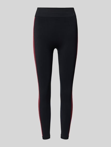 Produktfoto, Leggings mit Galonstreifen Modell 'SEAMLESS' von Tommy Hilfiger, czarny materiał z czerwonym paskiem bocznym, elastyczny pas, krój slim fit, materiał z domieszką stretchu, szerokość w rozmiarze S: 32 cm, długość wewnętrzna nogawki w rozmiarze S: 55 cm, detale z logo
