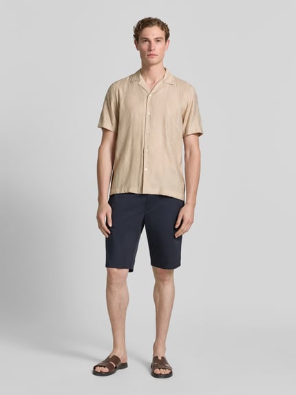 Männermodel trägt Modern Fit Freizeithemd mit Strukturmuster von Lindbergh aus Viskose-Mix mit Reverskragen und Knopfleiste, Ganzkörperansicht von vorne. Rückenlänge bei Größe M: 73 cm, Schulterbreite: 48 cm, Ärmellänge: 26 cm.