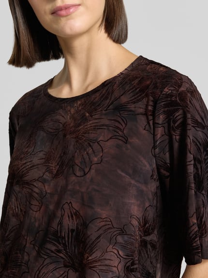 Vrouwenmodel draagt Blusenshirt im Allover-Look Model 'SESSOLANA' van FREE/QUENT in bruin met zwarte bloemen, materiaalmix met stretch, regular fit, ronde hals, ruglengte bij maat S 56 cm, Nahaufnahme Oberkörper.