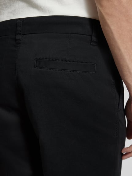 Mannenmodel draagt Regular Fit Chino uit katoenmix model 'TAAMIR PLEATED' van Armedangels, look: effen, detailopname rechterachterzijde