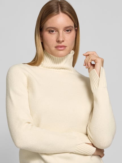 Frauenmodel trägt Rollkragenpullover mit Label-Detail von JAKE*S WOMAN CASUAL, unifarben, Strickoptik, Struktur, Nahaufnahme Oberkörper.