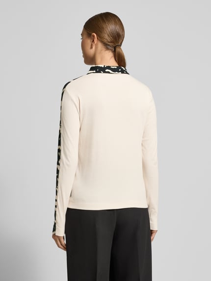 Kobiece model prezentuje Koszulkę polo z krótką listwą guzikową od Marc Cain, mieszanka bawełny i elastanu, krój regular fit, kołnierzyk polo, długość tyłu 56 cm przy rozmiarze 36, widok całej sylwetki z tyłu.