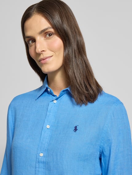 Vrouwenmodel draagt Overhemdblouse met knoopsluiting van Polo Ralph Lauren, zuiver linnen, los model, overhemdkraag, labelstitching, nahaufnahme bovenlichaam.