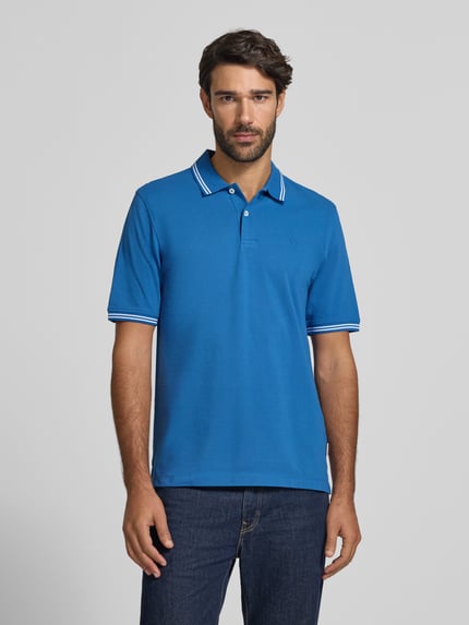 Männermodel trägt Slim Fit Poloshirt mit Label-Stitching von bugatti in Blau mit weißem Polokragen, reine Baumwolle, Ganzkörperansicht von vorne.