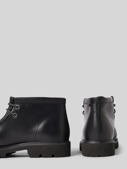 Produktfoto, schwarze Boots aus Leder Modell 'Cleyhill Top' von Clarks mit abgerundeter Spitze, sichtbarer Schnürung und strukturierter Sohle, Kontext: Herren Boots aus echtem Leder, Absatzhöhe 3 cm, Schafthöhe 11 cm, Schaftweite 11 cm.