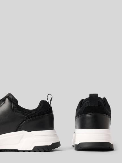 Produktfoto, Sneaker mit Label-Detail Modell 'HELADO' von Guess, schwarze Oberfläche, weiße strukturierte Sohle, runde Spitze, Zugschlaufe, Schnürverschluss, Absatzhöhe 5 cm, Schafthöhe 8 cm, Schaftweite 10 cm, Rückansicht und seitliche Ansicht, Herren Sneaker.