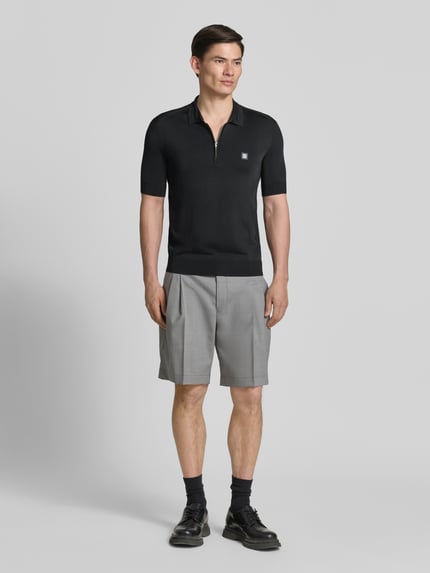 Męski model nosi Regular Fit Poloshirt aus Viskose-Mix Modell 'SAYFONG-4' od HUGO, kolor czarny, tekstura jersey, widok całej sylwetki z przodu.