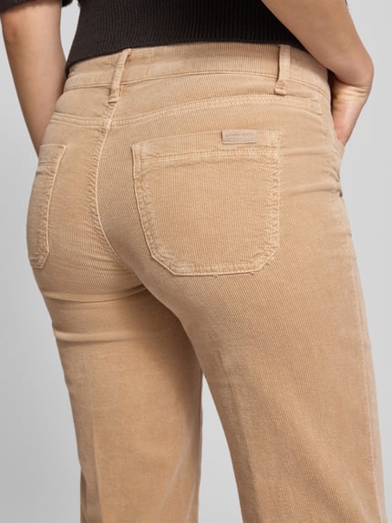 Frauenmodel trägt Bootcut Cordhose mit Eingrifftaschen Modell 'TESS' von Cambio, beiger Baumwoll-Mix mit Modal, Detailaufnahme Rückansicht.