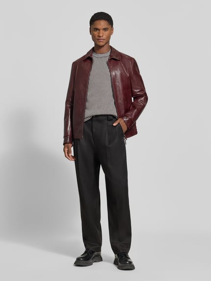 Mannermodel draagt Regular Fit gebreide pullover uit scheerwolmix met streepmotief van Armani Exchange, Heren, elastische boordjes, ruglengte maat M 70 cm, mouwlengte maat M 69 cm, zwart-wit met fijne textuur, volledig lichaam vooraanzicht.