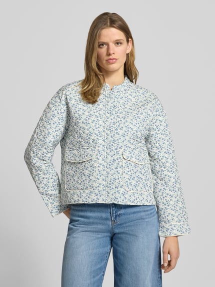 Frauenmodel trägt Regular Fit Hemdjacke mit Allover-Muster Modell 'HALLIE' von Only, florales Muster, blau-weiß, Stehkragen, Pattentaschen, Ganzkörperansicht von vorne.