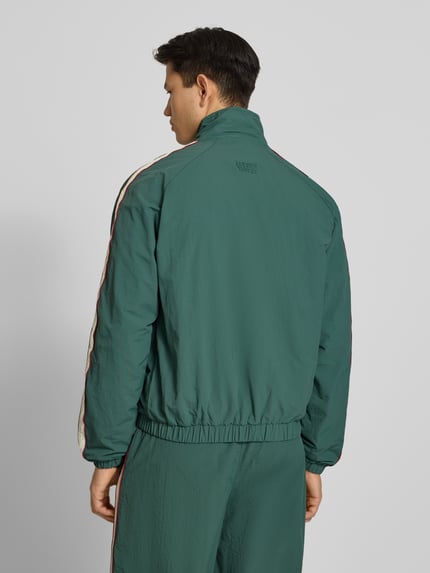 Männermodel trägt dunkelgrünes Trackjacket mit Label-Stitching Modell 'Slipstream' von PROHIBITED, Relaxed Fit, Ganzkörperansicht Rückansicht.