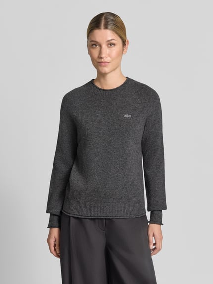 Frauenmodel trägt Regular Fit Pullover aus reiner Wolle von Lacoste in Dunkelgrau, weiche Textur, Damen Pullover, Ganzkörperansicht von vorne.