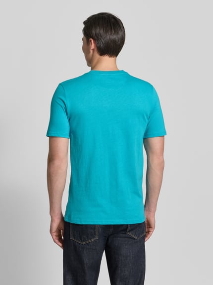 Mannelijk model draagt Regular Fit T-Shirt met Logo-Stitching van Scotch & Soda in helder turquoise, katoen, ronde hals, ruglengte 69 cm, regular fit, Ganzkörperansicht Rückansicht.