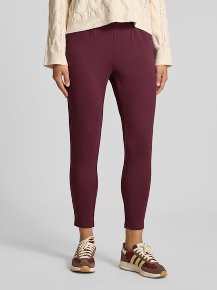 Frauenmodel trägt Gerade Hose mit Gürtelschlaufen Modell 'POPTRASH' von ONLY in Dunkelrot, glatte Textur, Damen Gerade Hose von ONLY, Nahaufnahme Unterkörper.