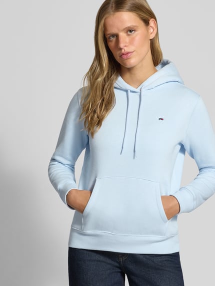 Frauenmodel trägt Regular Fit Hoodie aus Baumwoll-Mix von Tommy Jeans in Hellblau mit Kängurutasche, Damen Hoodie, Nahaufnahme Oberkörper.