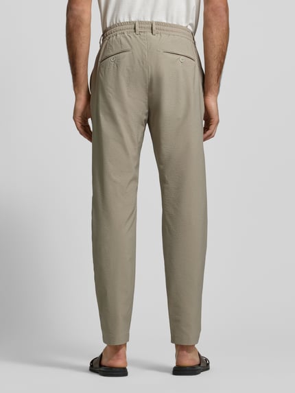 Männermodel trägt Slim Fit Stoffhose mit Strukturmuster von CRUNA, Elastischer-Material-Mix, Gesäßtaschen, Bund, Eingrifftaschen, Ganzkörperansicht Rückansicht.