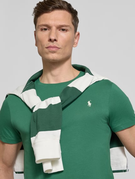 Männermodel trägt Regular Fit T-Shirt aus reiner Baumwolle von Polo Ralph Lauren in Grün mit Logo-Stitching, Nahaufnahme Oberkörper.