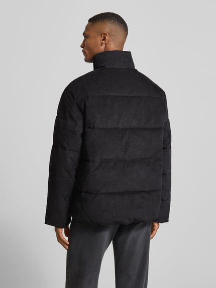 Männermodel draagt Regular Fit Gewatteerd jack uit corduroy van Tom Tailor Denim in effen zwart, met opstaande kraag en lange mouw, Steekzakken, geribde rompzoom, labelstitching, achterkant, Ganzkörperansicht Rückansicht.
