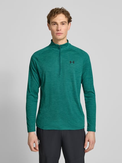 Męski model nosi Sweatshirt mit kurzem Reißverschluss und Logo-Print von Under Armour, zielony, prosty krój, stójka, nadruk z logo, długość tyłu w rozmiarze m: 74 cm, długość rękawów w rozmiarze m: 64 cm, zdjęcie całej sylwetki z przodu.