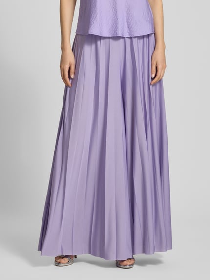 Frauenmodel trägt Wide Fit Stoffhose in Falten-Optik Modell 'Samantha' von GUIDO MARIA KRETSCHMER WOMAN, fliederfarben, Nahaufnahme Oberkörper, Elastikbund, Bundweite 36 cm, Innenbeinlänge 75 cm, glatte Textur.