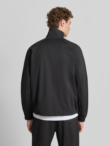 Männermodel trägt Sweatjacke mit Stehkragen und Zweiwege-Reißverschluss von Emporio Armani, Schwarz, Lyocell-Mix mit Viskose-Anteil, Regular-Fit, Rückenlänge bei Größe M 68 cm, Ärmellänge 84 cm, Ganzkörperansicht Rückansicht.