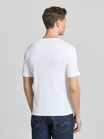 Männermodel trägt weißes Herren T-Shirt aus reiner Baumwolle, Slim-Fit, Modell 'ENIL' von Drykorn, Rückenlänge 66 cm, Ganzkörperansicht Rückansicht.