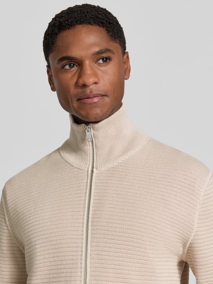 Männermodel trägt Regular Fit Strickjacke aus reiner Baumwolle von Marc O'Polo in Beige, feine Struktur, Nahaufnahme Oberkörper, Herren Pullover von Marc O'Polo.