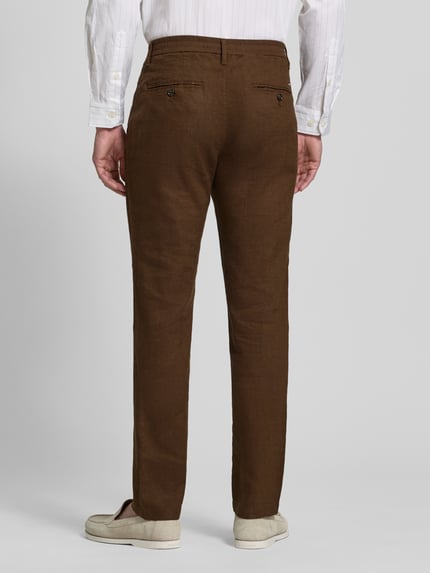 Męski model nosi Regular Fit Leinenhose mit Logo-Stitching Modell 'Denton' od Tommy Hilfiger, jednolity brązowy len-mix, widok całej sylwetki z tyłu.