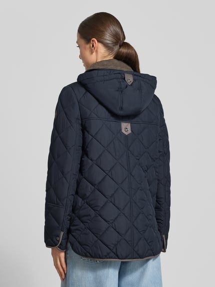 Frauenmodel trägt Relaxed Fit Steppjacke mit abnehmbarer Kapuze von Gil Bret in Dunkelblau mit Rautensteppung, Ganzkörperansicht Rückansicht. Damen Steppjacke von Gil Bret.