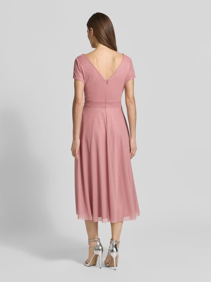 Vrouwenmodel draagt glanzende Schimmerndes Cocktailkleid met V-hals van Vera Mont in roze tule, A-lijn midi-jurk, ruglengte maat 36: 100 cm, borstwijdte maat 36: 42 cm, glanzende textuur, volledige achterkantaanzicht.