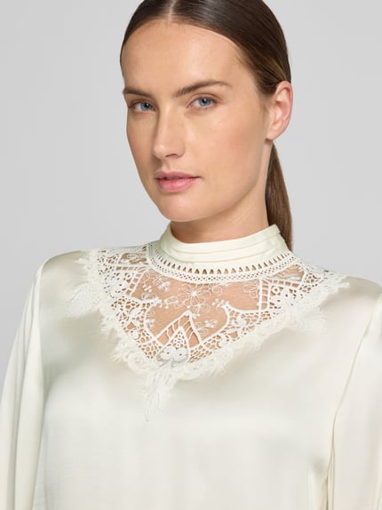 Vrouwenmodel draagt Regular fit blouse met lange mouwen van pure viscose van Jake*s Collection, gebroken wit met kantdetails, Nahaufnahme bovenlichaam.