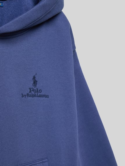 Meisje draagt Regular Fit Hoodie uit katoenmix van Polo Ralph Lauren Teens, look: effen, applicatie met labelstitching, gestikt logo, kangoeroezak, capuchon, lange mouwen, mouwboord en rompzoom geribd, materiaalverwerking: sweat, detailopname bovenstuk.