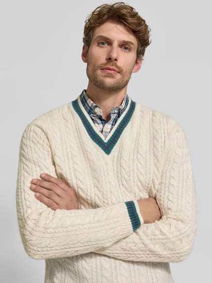 Männermodel trägt Strickpullover mit Woll-Anteil von MCNEAL in Creme, Zopfmuster, gerippte Abschlüsse, Nahaufnahme Oberkörper, Woll-Mix.