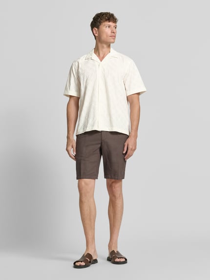 Männermodel trägt Relaxed Fit Freizeithemd aus reiner Baumwolle Modell 'HAMISH' von Selected Homme, helles Creme, leichte Struktur, Herren, Ganzkörperansicht von vorne.