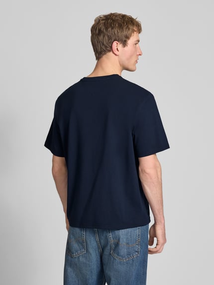 Männermodel trägt Regular Fit T-Shirt aus reiner Baumwolle von Tommy Jeans in Optik: Unifarben, Ganzkörperansicht Rückansicht.