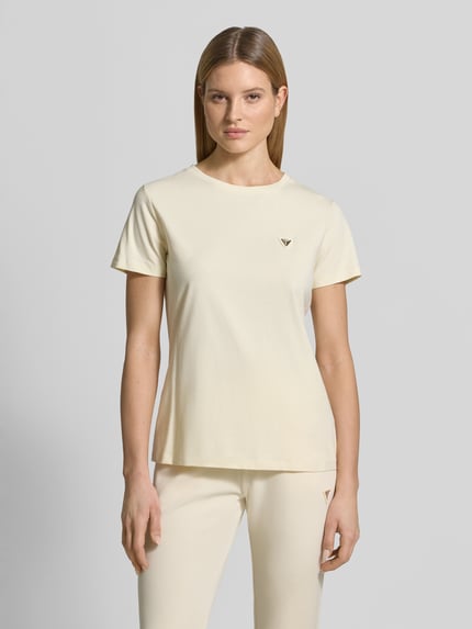 Vrouwenmodel draagt Regular Fit T-Shirt met Logo-Applikation model 'Colette' van Guess Activewear in lichtgeel, ronde hals, elastische katoenmix, ruglengte maat S 60 cm, frontale volledige lichaamsopname.