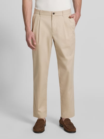 Männermodel trägt Tapered Fit Hose mit Gesäßtaschen von MCNEAL in Beige, Material-Mix mit Baumwoll-Anteil, Drapierungen, Ganzkörperansicht von vorne.