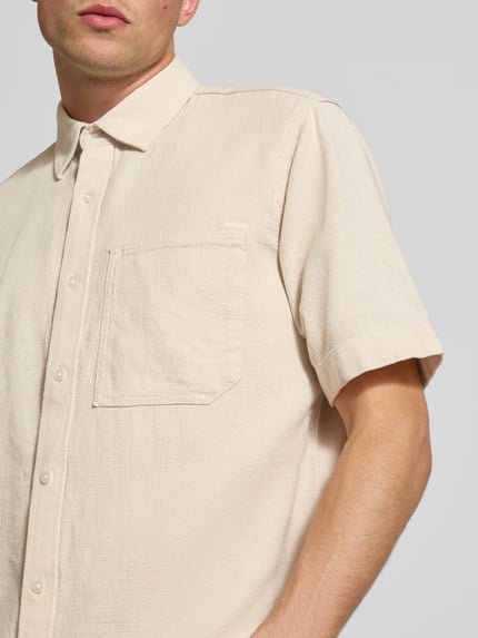 Männermodel trägt Regular Fit Freizeithemd aus reiner Baumwolle von G-Star RAW in Beige mit strukturierter Oberfläche, Nahaufnahme Oberkörper.