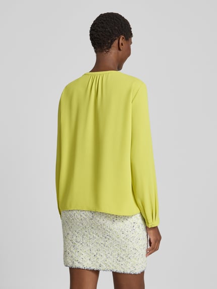 Männermodel trägt Relaxed Fit Bluse mit obszyciem falbanami od Marc Cain, dekolt w serek, z długim rękawem, Długość tyłu 58 cm, Długość rękawów 61 cm, Ganzkörperansicht Rückansicht
