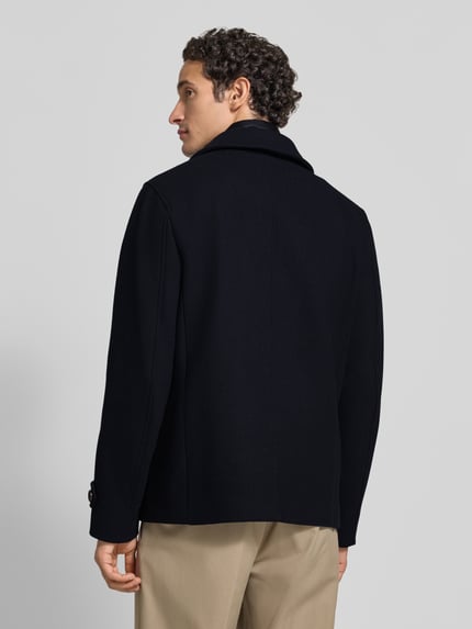 Männermodel trägt Jacke im 2-in-1-Look mit Ärmelriegeln von Geox in Schwarz, strukturierte Oberfläche, Ganzkörperansicht Rückansicht, Regular Fit, Stehkragen, Reißverschluss und Knopfverschluss, Zweireiher, Rückenlänge 70 cm, Schulterbreite 44 cm, Brustweite 52 cm, Ärmellänge 68 cm.